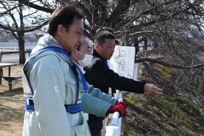 防災訓練の様子（職員と河川を確認する市長の写真）