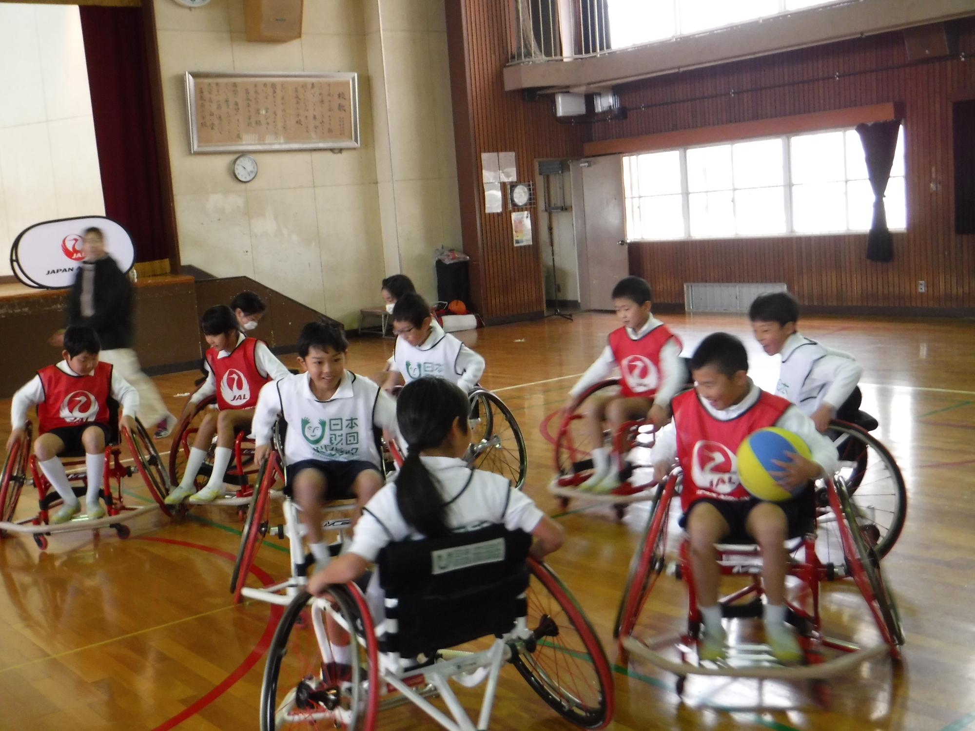 車いすバスケットボールをしている小学生たちの写真