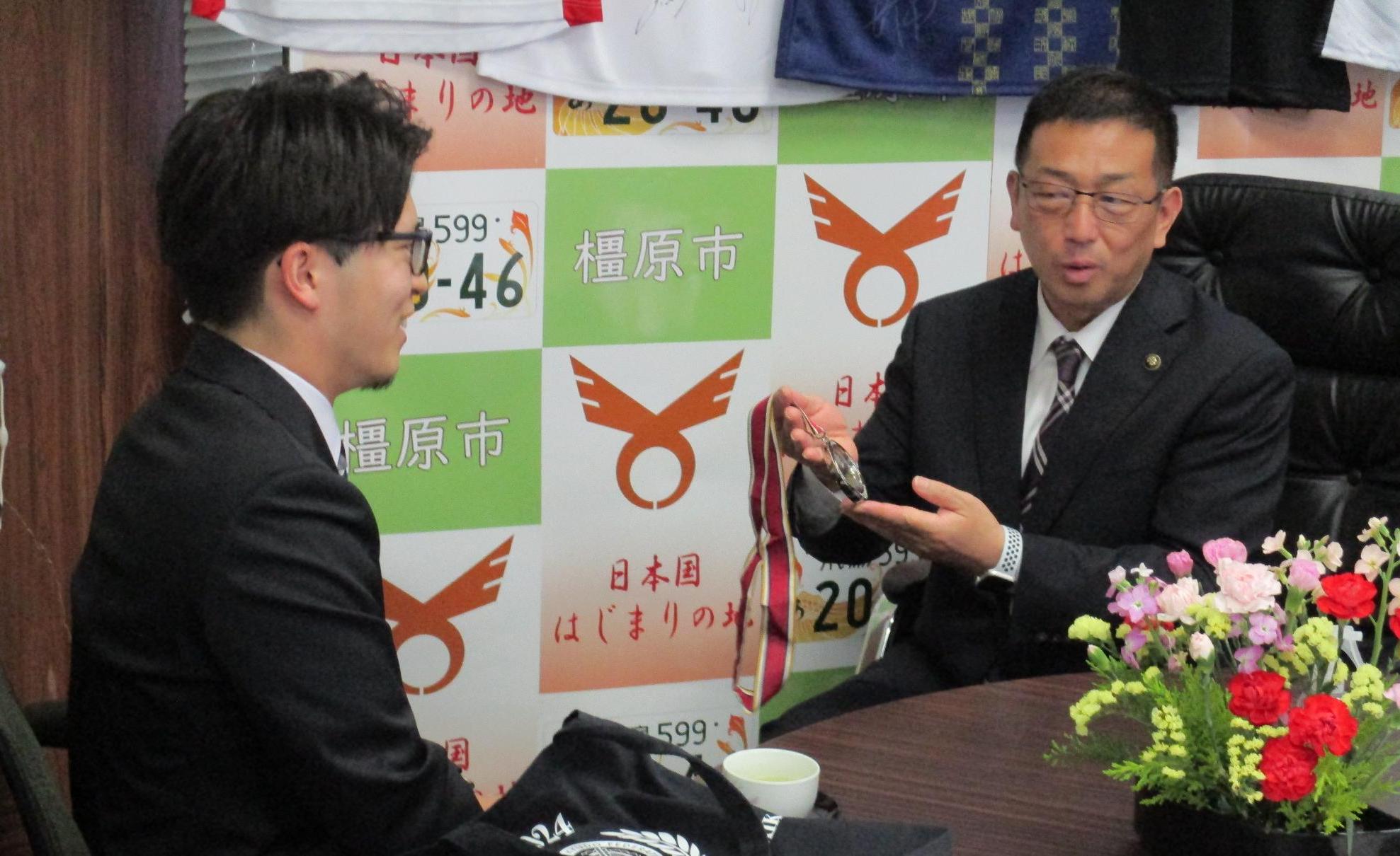亀田市長にメダルを披露する西田選手(左)