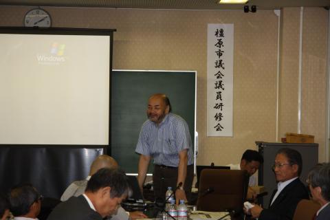 議員達の前で講義を行う新川達郎氏の写真
