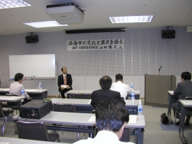 議員達を前に座っている山田勝久氏の写真