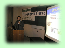 スライドを見ながら講義を行う板倉信一郎氏の写真