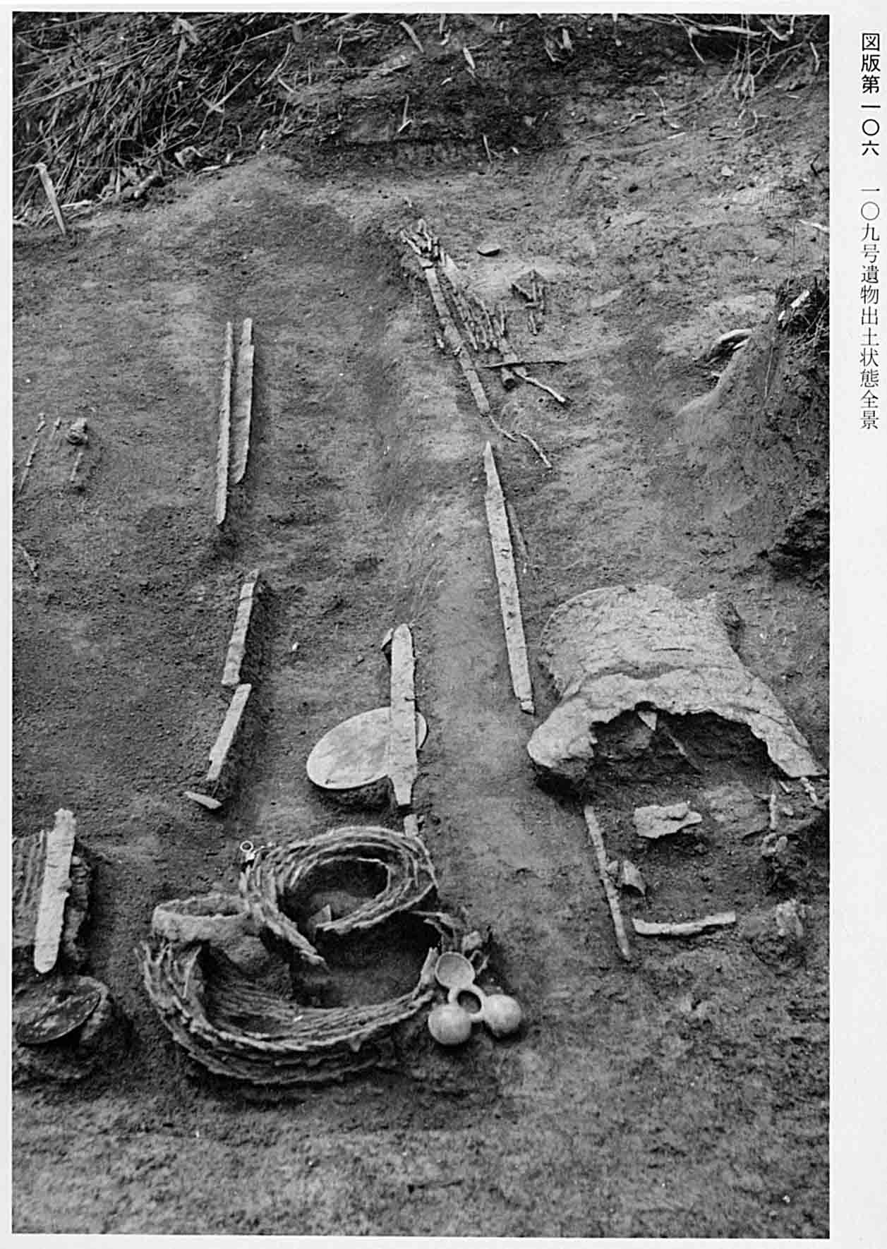 剣や鎧などが並べられている、図版106 109号遺物出土状態全景のモノクロ写真
