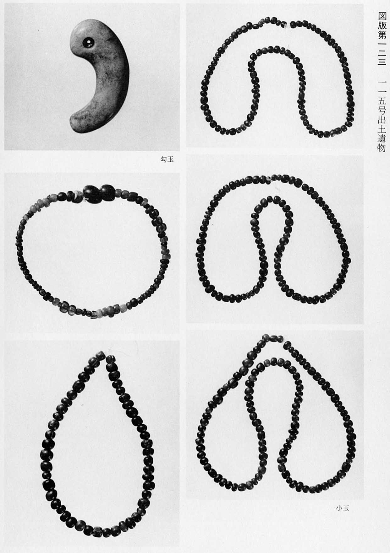 曲がった石の勾玉と、小さい石をつなぎ合わせた5つの小玉がそれぞれ撮影されている、図版123 115号出土遺物のモノクロ写真