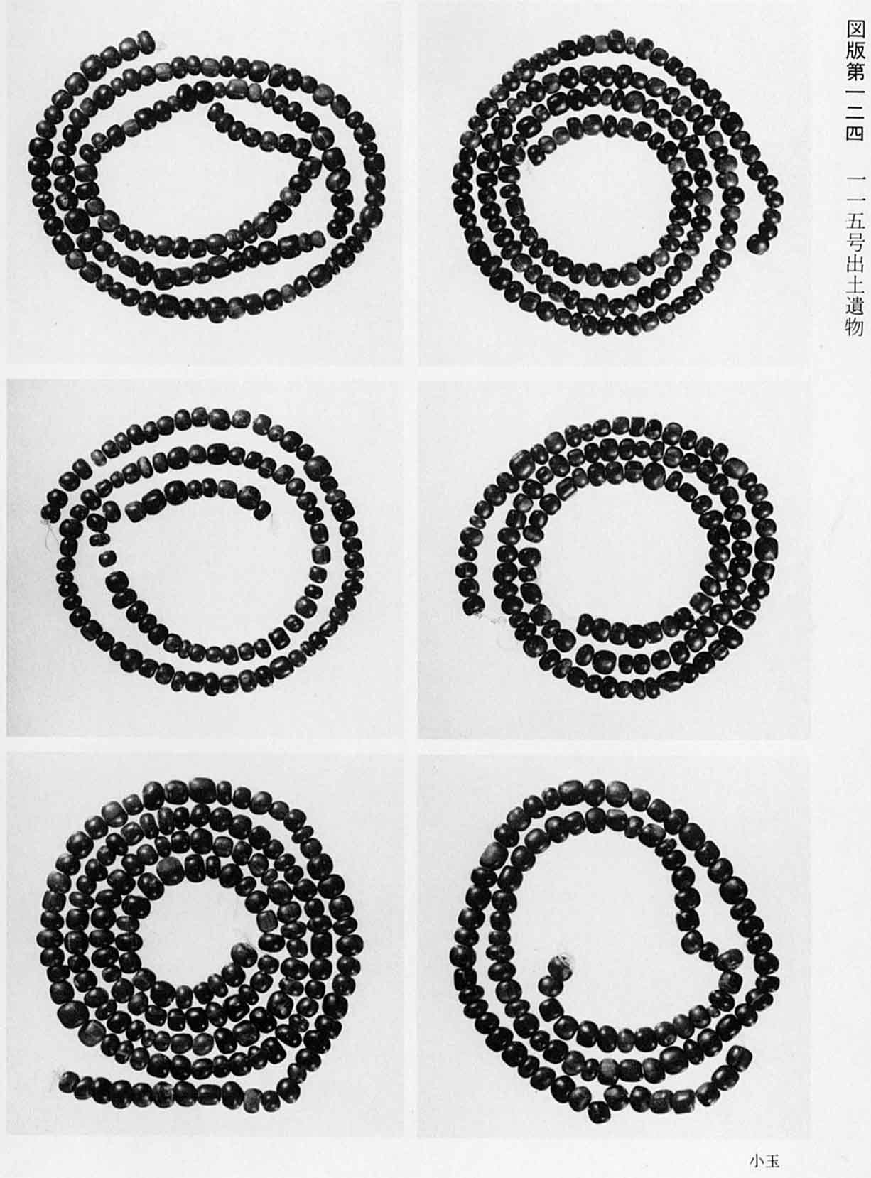 小さな石をつなぎ合わせて渦巻き状に置かれている6種類の小玉がそれぞれ撮影されている、図版124 115号出土遺物のモノクロ写真