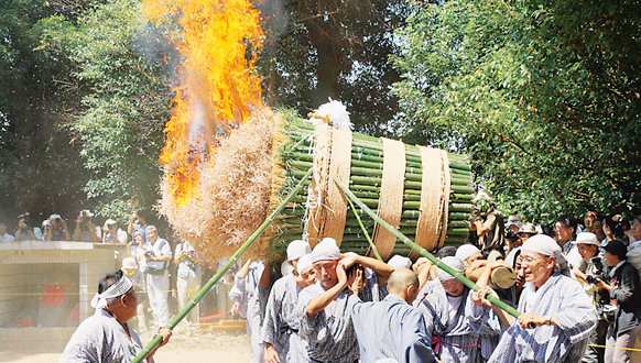 多くの竹を一つに縛った物の先端に火をつけて複数の男性が運んでいるほうらんや火祭の写真