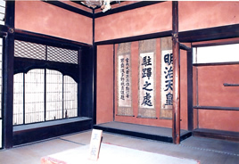 赤い壁に数本の掛軸が掛けられた称念寺庫裡の客殿内観写真