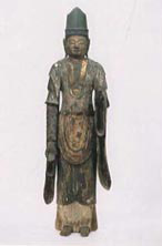 丈が長い着物を身に纏っている木造天部立像の写真