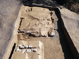 下段墳丘南西コーナー部と藤原宮期の石組み溝の写真