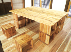 木製のフローリングの室内に木製のテーブルとイスが置かれている写真