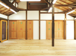 木製のフローリングに白い壁に木製の襖がある建物の内装の写真