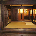 木製の襖が開けられており畳が張られている部屋が見える日本家屋の内装の写真