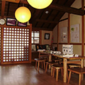 部屋の隅に木製のテーブルや椅子が置かれた建物の内観の写真