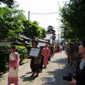 着物姿の女性や茶人の格好をした男性などが町を行進している様子を撮影した写真