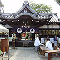 神社の前で長机を揃えて秋祭りの準備をしている人たちを撮影した写真