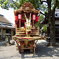 金色の龍の頭が印象的な今井町と書かれた提灯を吊るしている山車の写真