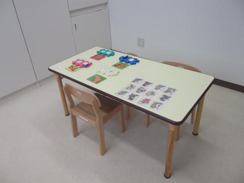 言語訓練室内のテーブルに言語訓練用の道具が複数並べられている写真