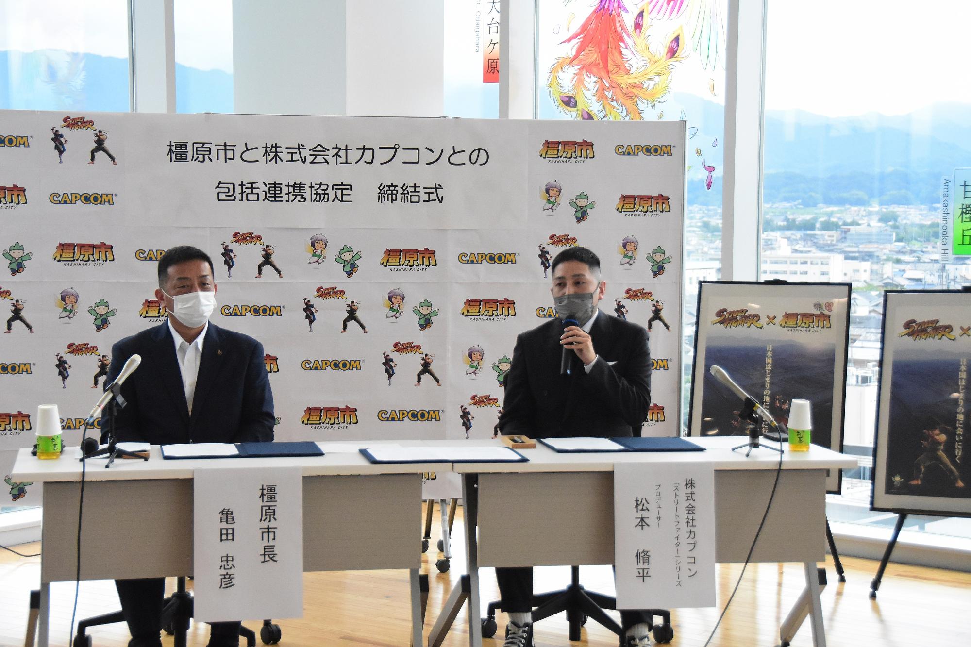 亀田市長の横で、締結式中にマイクを持って話している松本氏の写真