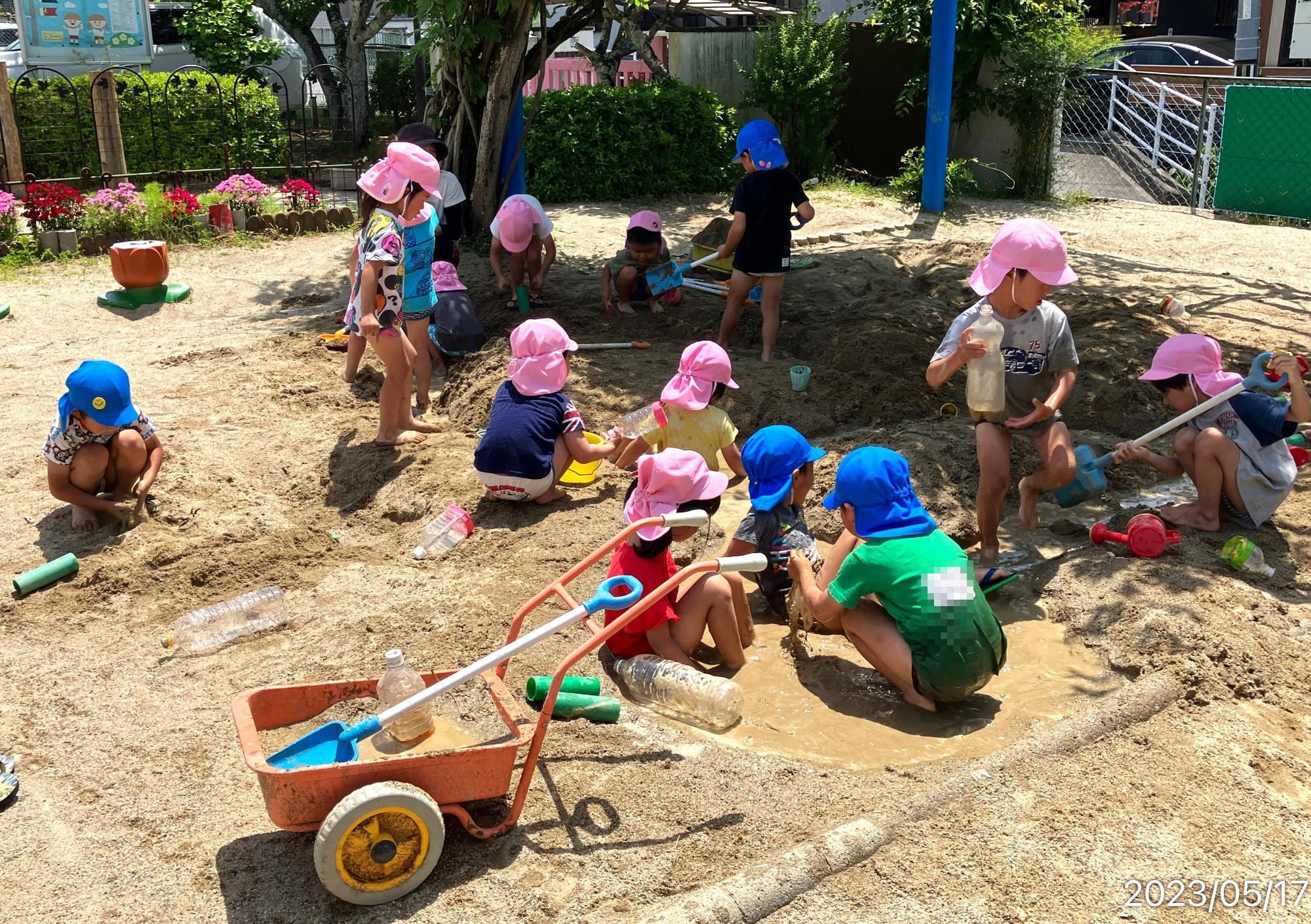 砂場で泥んこ遊びをしている写真