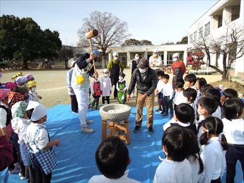園庭でうすと杵を使ってもちつきをしている写真