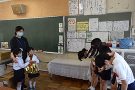 6年生の生徒4人が1年生の担任の先生と児童2人に頭を下げて挨拶している写真
